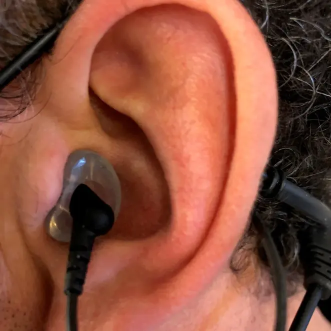 A smoke custom Clarity Aloft adapter worn in the ear, close up
