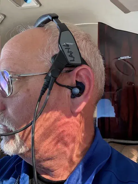 A pilot wearing a Bose ProFlight headset with a custom Big Ear adapter
